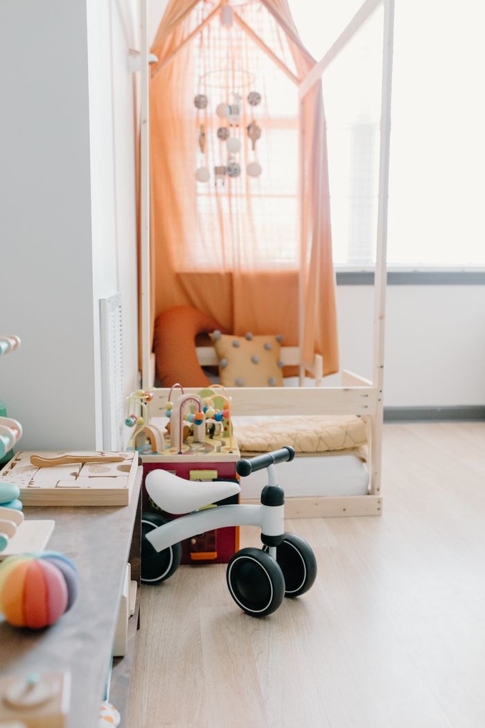 Mastering the First Impression: Your intriguing post title goes here A bright and cozy children's playroom featuring a bed with canopy and wooden toys.