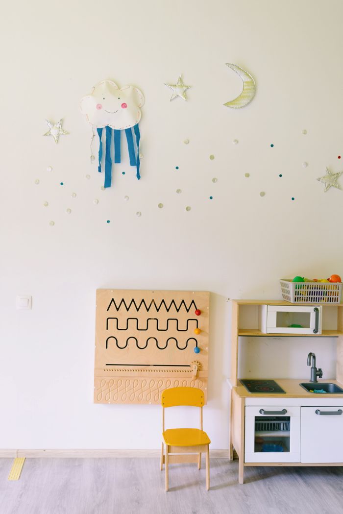 The Art of Drawing Readers In: Your attractive post title goes here Bright children's room with toy kitchen, sensory board, and cheerful wall decorations.